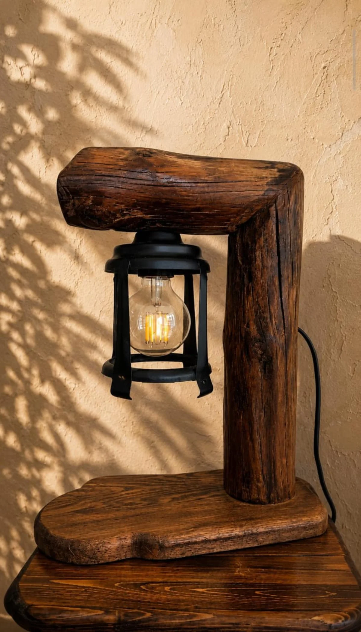 Sculptural handmade wooden lantern glowing with warm light